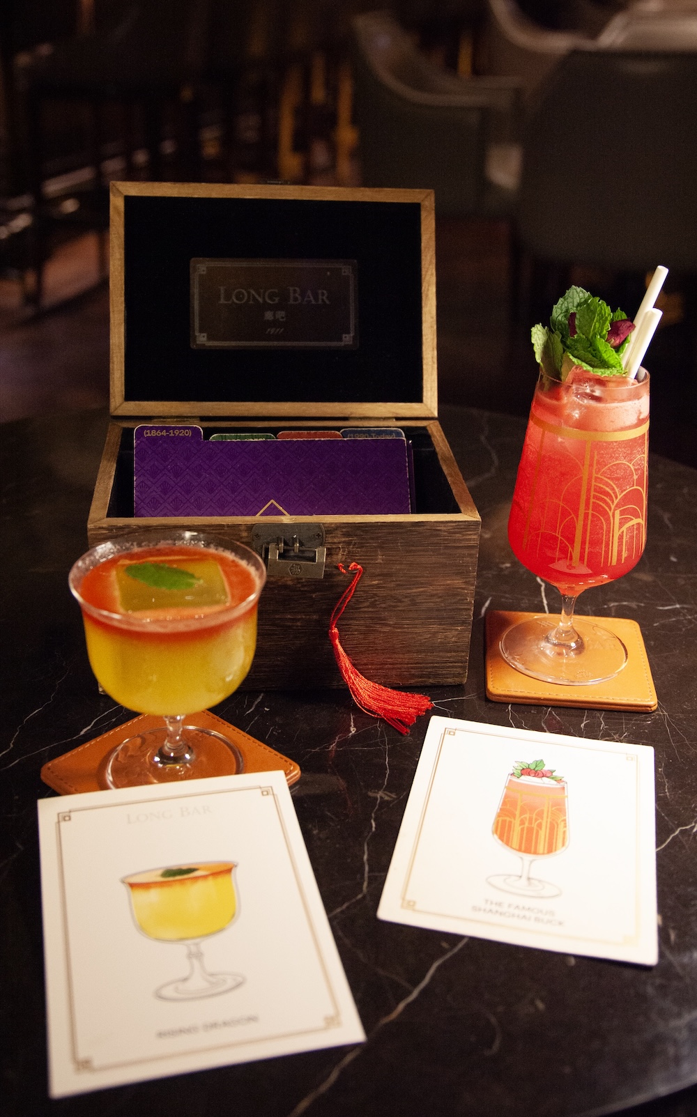 De cocktailkaart als avontuur in een schatkist in de Long Bar van het Waldorf Astoria hotel in Shanghai. Doe je het kistje open dan straalt er licht op je gezicht
